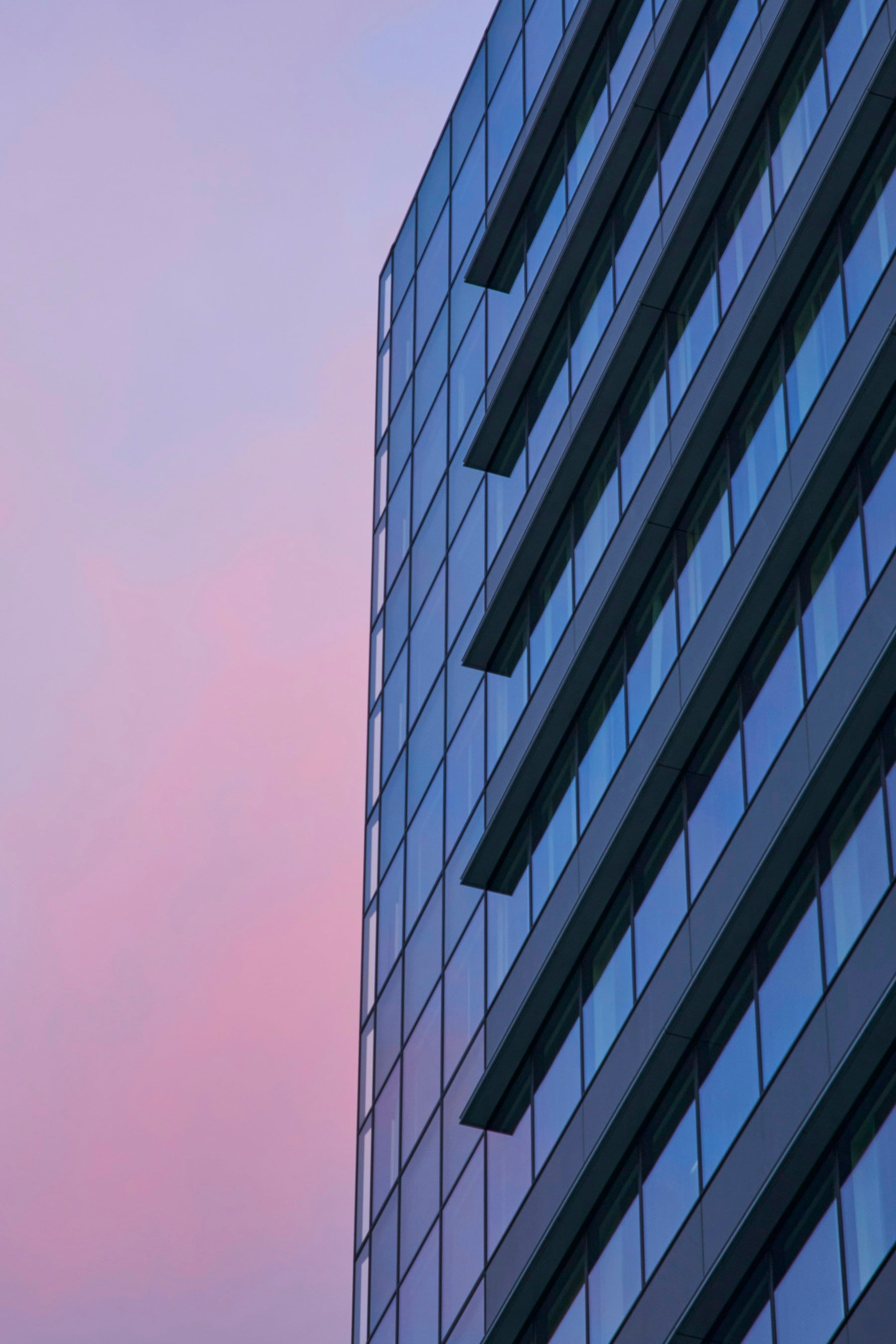 Reflective glass architecture against a pastel sky